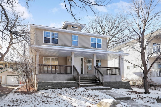 view of property featuring a garage, an outdoor structure, and covered porch