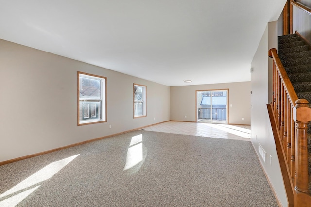 unfurnished room featuring a wealth of natural light and light colored carpet