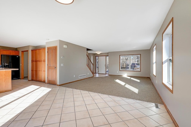 unfurnished living room featuring light colored carpet