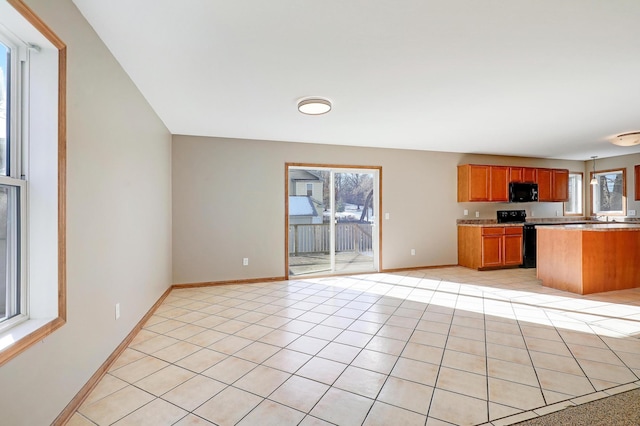 kitchen featuring light tile patterned floors, black appliances, and a healthy amount of sunlight