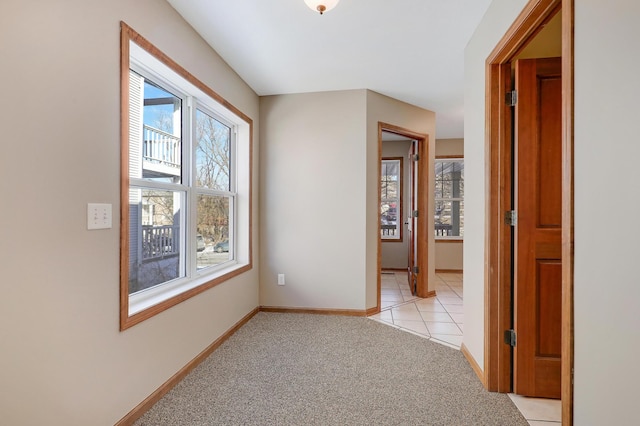 hallway with a healthy amount of sunlight and light carpet