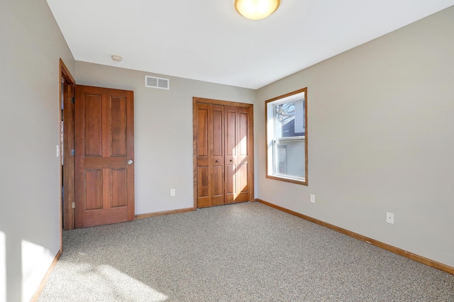 unfurnished bedroom featuring light carpet and a closet