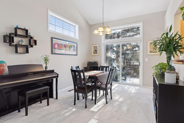 carpeted dining area featuring a notable chandelier and high vaulted ceiling