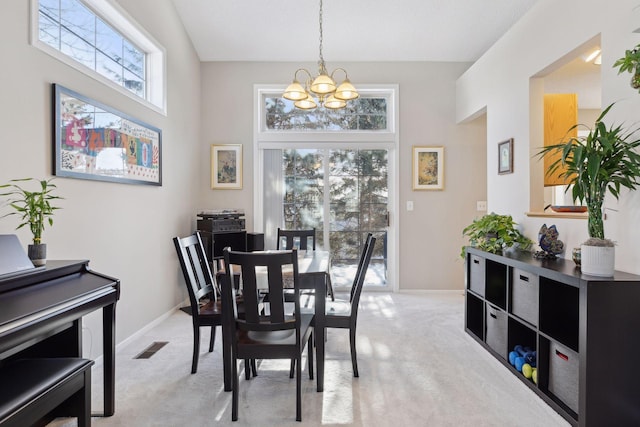 carpeted dining space featuring a towering ceiling and an inviting chandelier