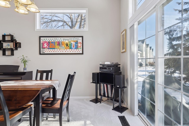 dining space featuring carpet flooring and a notable chandelier