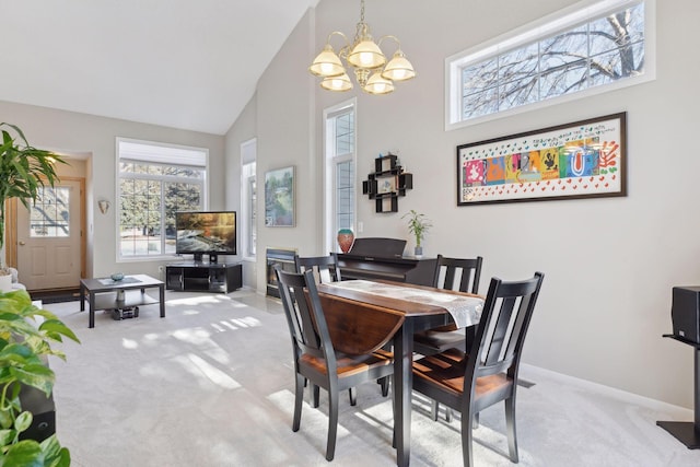 carpeted dining space featuring high vaulted ceiling and a chandelier