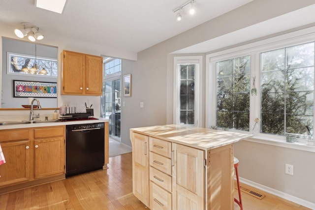 kitchen featuring dishwasher, sink, light wood-type flooring, pendant lighting, and butcher block countertops