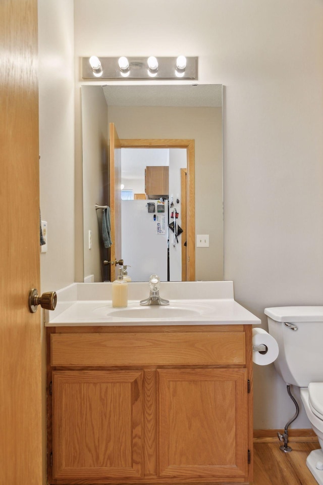 bathroom featuring vanity, toilet, and wood-type flooring