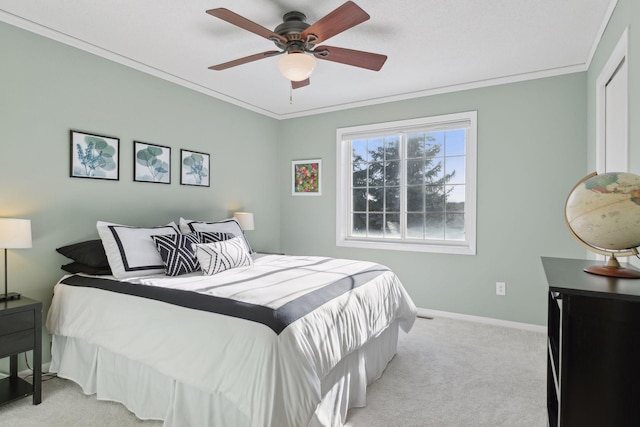 carpeted bedroom featuring ceiling fan and crown molding