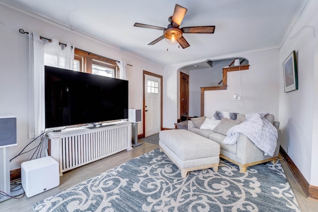 living room with crown molding, ceiling fan, and light hardwood / wood-style flooring