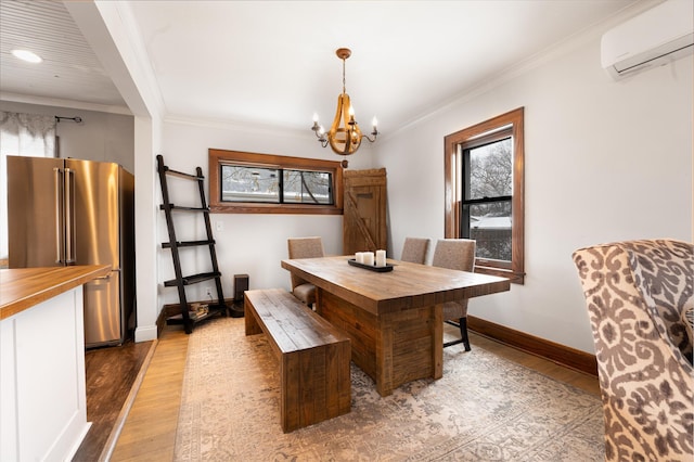 dining area with light hardwood / wood-style floors, an inviting chandelier, crown molding, and a wall mounted AC