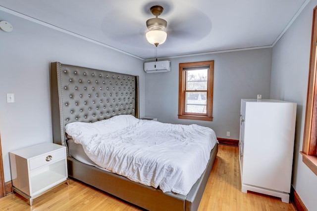 bedroom featuring ceiling fan, light wood-type flooring, crown molding, and an AC wall unit