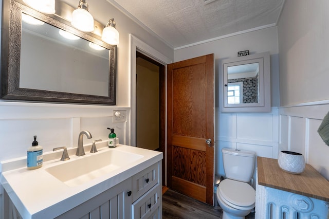 bathroom featuring toilet, wood-type flooring, vanity, and a textured ceiling