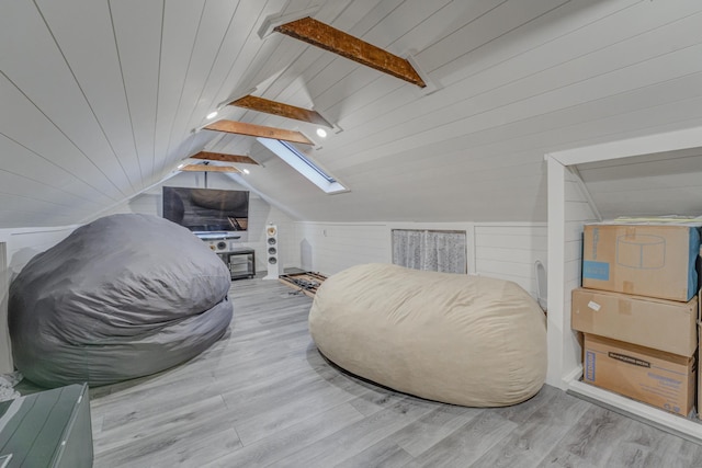 bonus room with wooden ceiling, lofted ceiling with skylight, wooden walls, and light hardwood / wood-style flooring