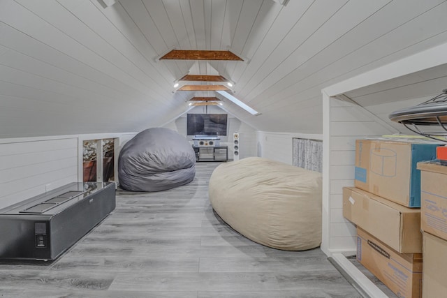 bedroom with hardwood / wood-style flooring, wooden walls, wood ceiling, and lofted ceiling with skylight