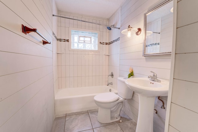 full bathroom featuring tiled shower / bath combo, tile patterned floors, sink, and toilet