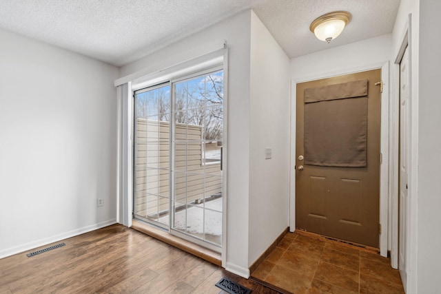 entryway with dark hardwood / wood-style floors and a textured ceiling