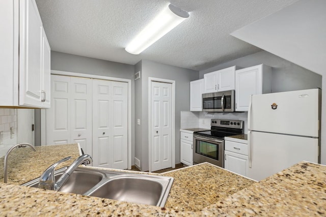 kitchen featuring white cabinetry, sink, decorative backsplash, and stainless steel appliances