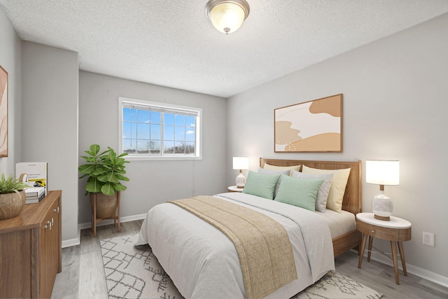 bedroom featuring a textured ceiling and light hardwood / wood-style floors