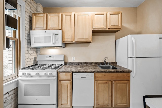 kitchen with light brown cabinetry, sink, and white appliances