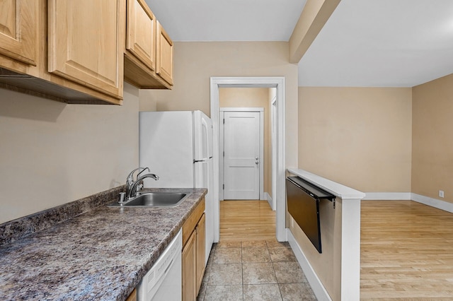 kitchen featuring white dishwasher, light brown cabinetry, and sink