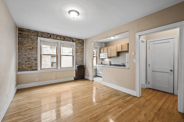 kitchen featuring radiator, light brown cabinets, white appliances, and light hardwood / wood-style floors