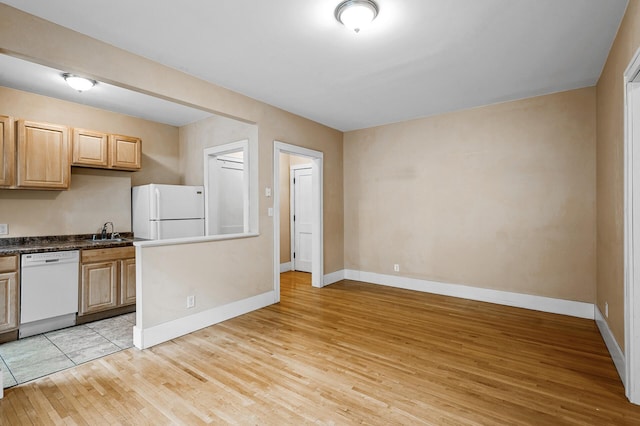 kitchen featuring white appliances, light hardwood / wood-style floors, sink, and light brown cabinets