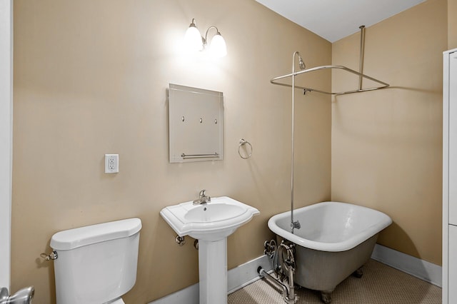 bathroom featuring toilet, a bath, and sink