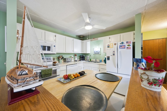 kitchen featuring white cabinetry, sink, white appliances, and a textured ceiling