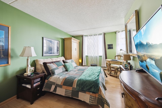 bedroom with light hardwood / wood-style floors and a textured ceiling