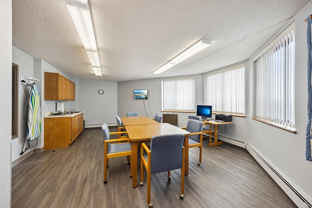 dining space with dark hardwood / wood-style flooring, a baseboard heating unit, an AC wall unit, and a textured ceiling