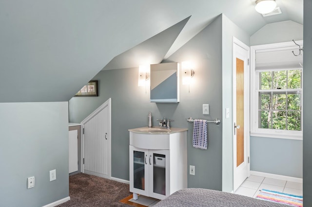 tiled bedroom with sink and lofted ceiling