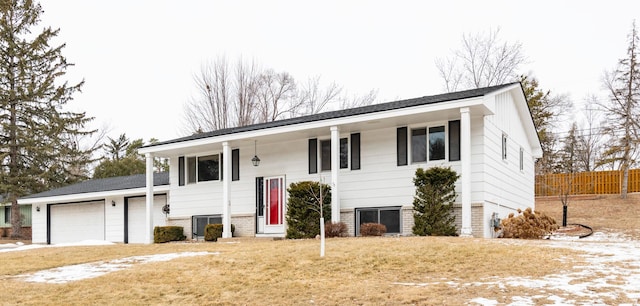 bi-level home featuring a garage and a front lawn