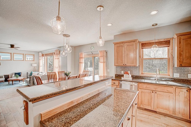 kitchen with sink, decorative light fixtures, stainless steel dishwasher, and decorative backsplash