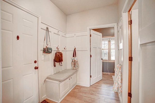 mudroom featuring light hardwood / wood-style flooring and a textured ceiling