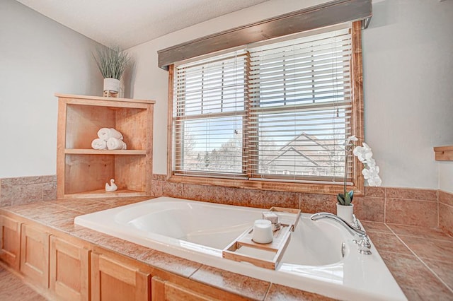 bathroom featuring tiled tub and a textured ceiling