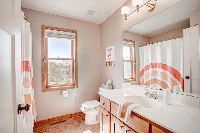 bathroom with vanity, a textured ceiling, and toilet