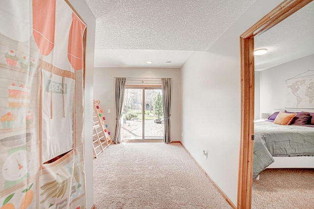 corridor featuring a textured ceiling and carpet