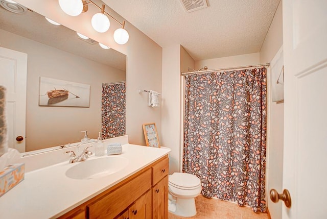 bathroom featuring tile patterned flooring, vanity, a textured ceiling, and toilet