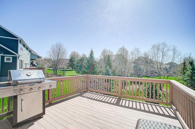 wooden terrace featuring grilling area and a yard