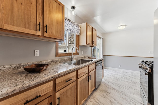 kitchen featuring sink, stainless steel appliances, and light stone countertops