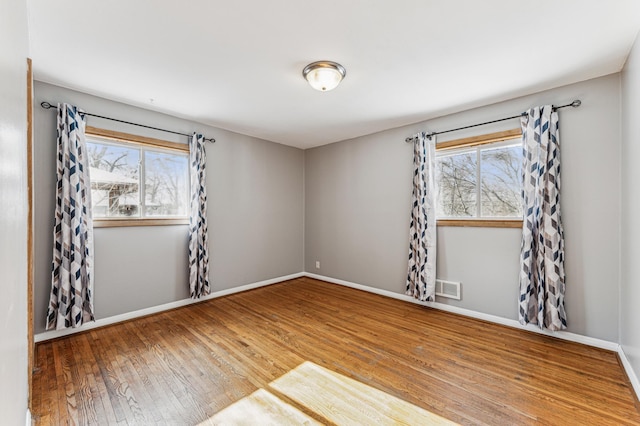 empty room featuring hardwood / wood-style flooring and plenty of natural light