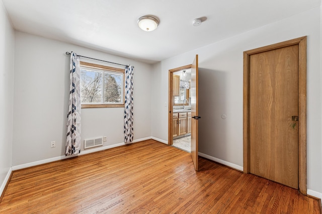 unfurnished room with wood-type flooring and sink