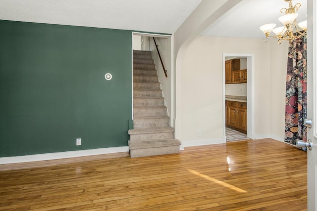 interior space with a textured ceiling, hardwood / wood-style floors, and a chandelier