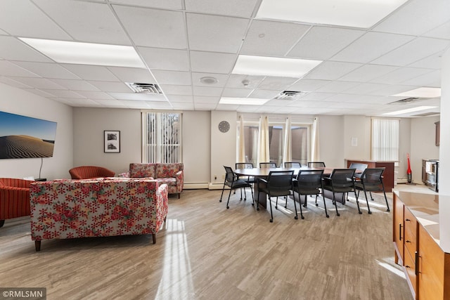 living room featuring light hardwood / wood-style flooring and a paneled ceiling