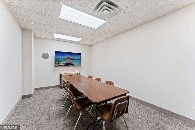 dining space with a drop ceiling and carpet