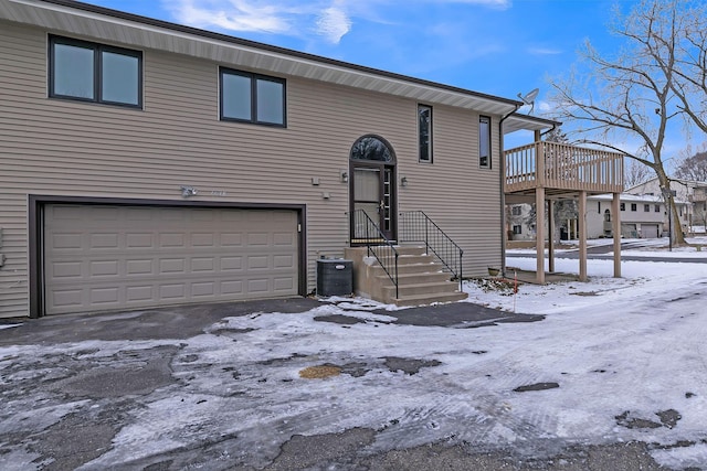 view of front of property with a garage and central AC