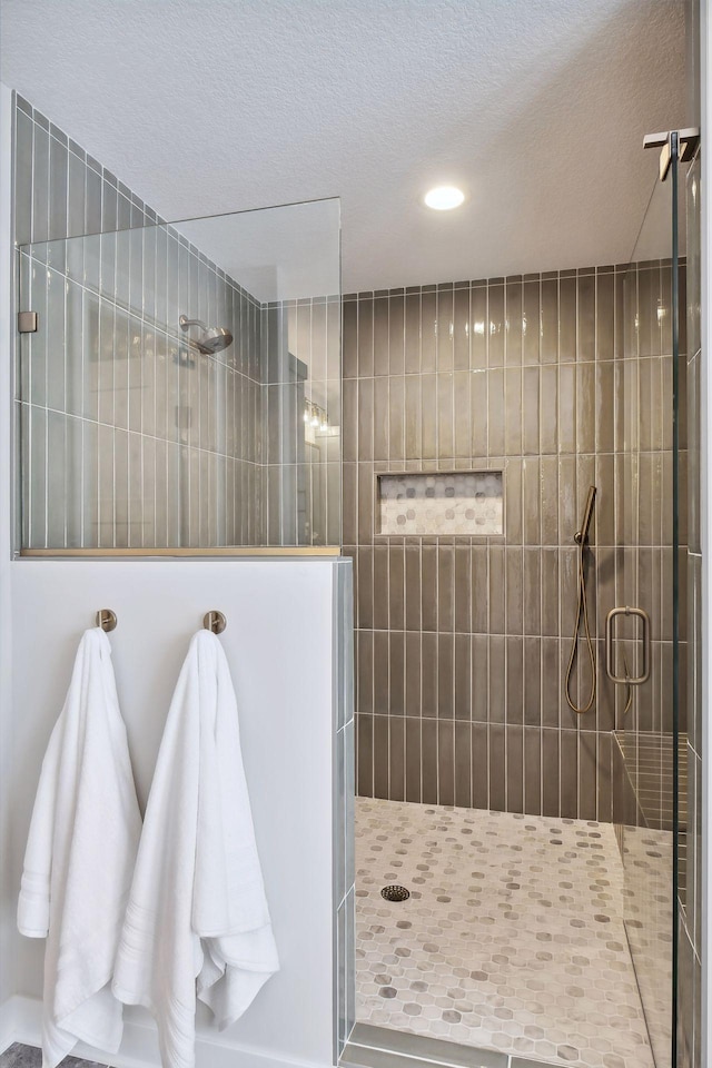 bathroom featuring tiled shower and a textured ceiling