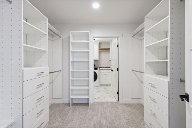 spacious closet featuring washer / dryer and sink