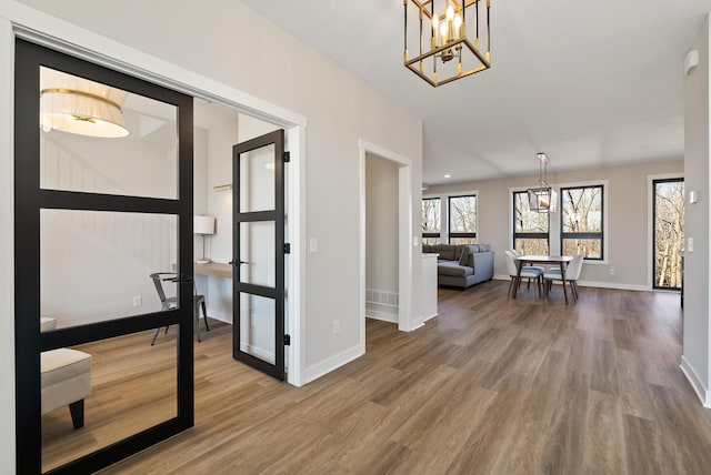 18436 56th Ct N, Plymouth, MN 55446 - entryway featuring wood finished floors, a chandelier, and baseboards